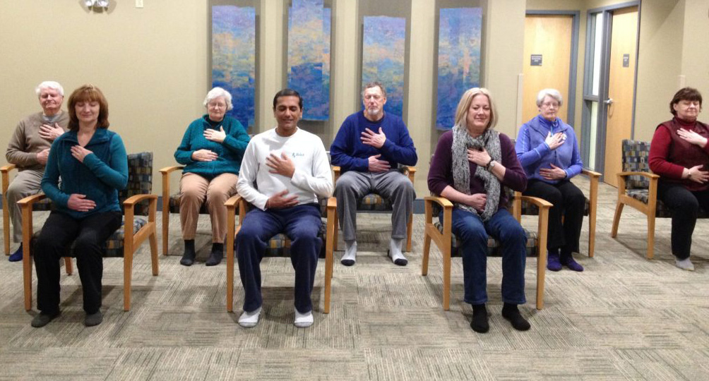A diverse group clapping during a seated event in a cozy room.